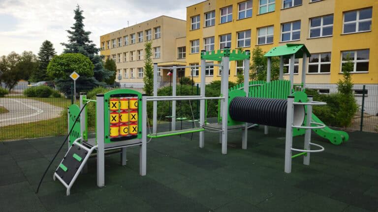 Platforma z drabinkami, zjeżdżalnia i elementy do ćwiczeń na zewnątrz.