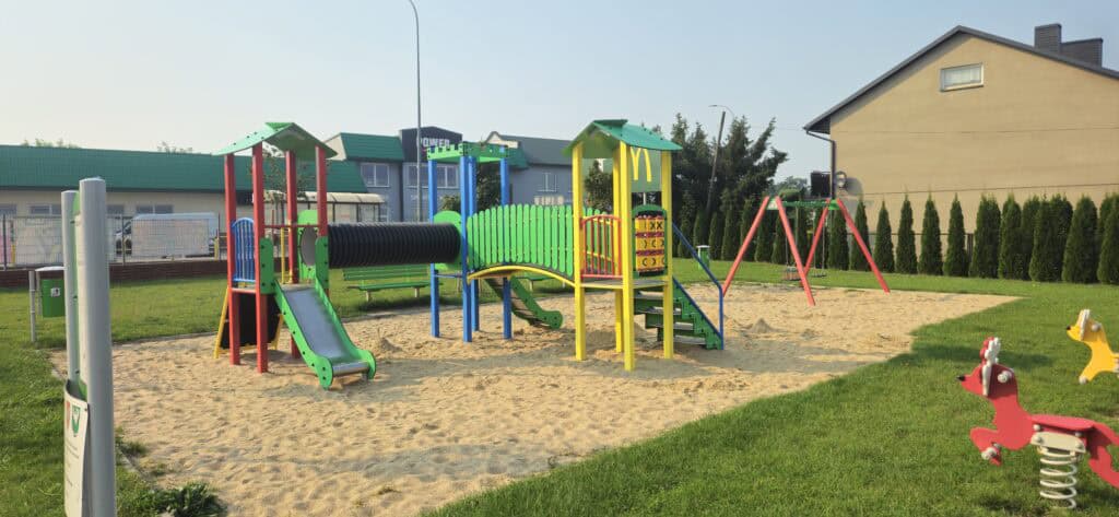 Szeroki widok placu zabaw i siłowni zewnętrznej przy remizie strażackiej w Kowalach Pańskich – Kolonia w gminie Kawęczyn